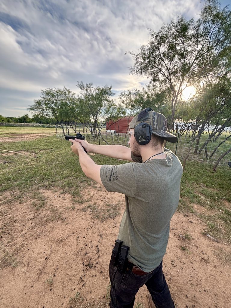 Shooter practicing handgun skills during an outdoor firearms training session